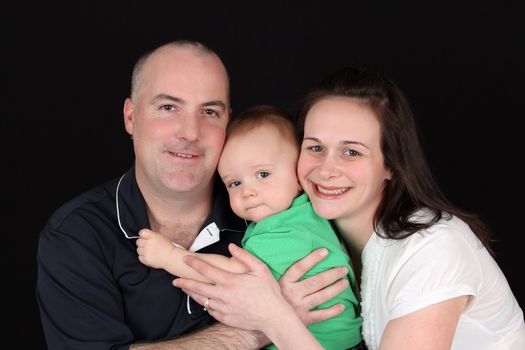 Family of three against a black background