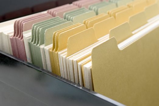Closeup of an opened box of index cards.  Black box, white cards with dividers coloured pink, green and yellow.