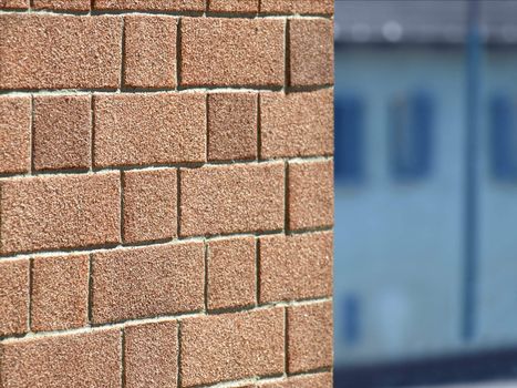 Wall of red bricks over a blue out of focus background
