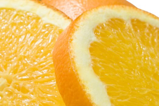 Close up (macro) of two slices of orange (foreground) and an upturned half-orange (middle-ground) with white background.