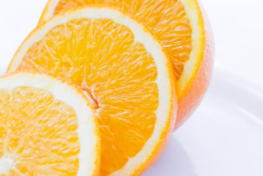 Orange sliced on to a white plate.  White background.  