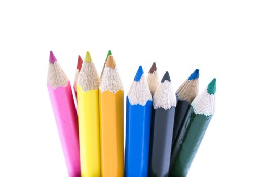 Coloured pencils bunched together and standing uprigh against white background.  Upper third visible.  Colours:  Pink, red, yellow, green, orange/ochre, light blue, brown, black, dark blue, green.