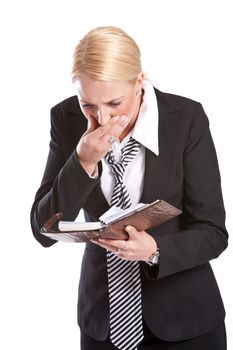 Pretty blond businesswoman is looking shocked at her diary