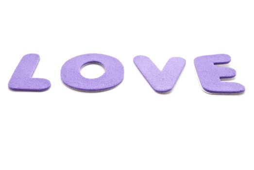 The word 'Love' spelled out in mauve lettering  on a white background.