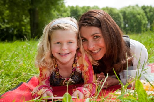 Beautiful mother and daughter together outdoors in the field