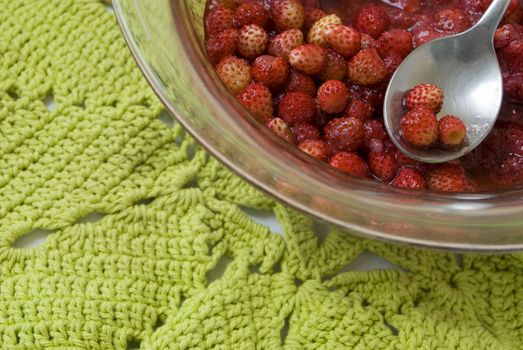 Portion of sweet wild strawberry jam. The spoon is applied