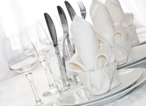 Decoratively folded napkins with glasses, glasses and cutlery