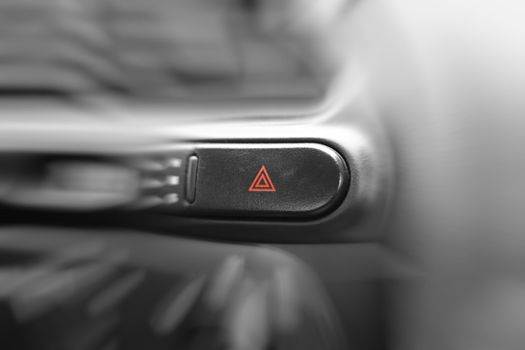 Car emergency lights button on cockpit. Very shallow DOF, focus on triangles on emergency lights button.