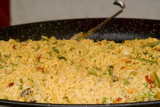 a pan full of paella being cooked in a large pan