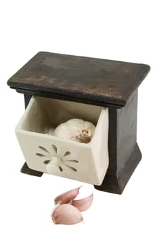 A garlic bulb and cloves in a storage container