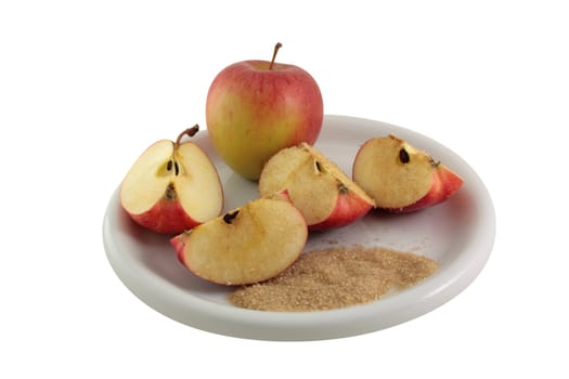A plate with two apples on it, one whole and the other cut into four segments and covered in sugar