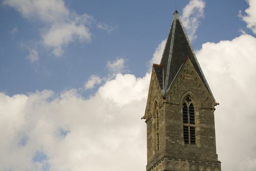 The spire of a church against a bright cloudy sky