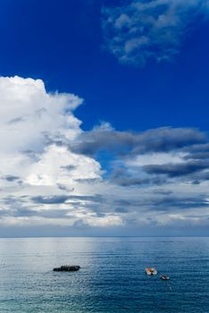 It is beautiful sky and ocean with fishing boats.