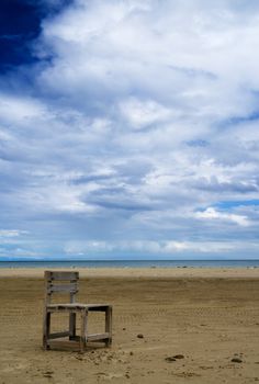 It is a lonely one chair on the beach.