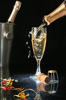 Pouring a champagne flute for celebration time. (with confetti)