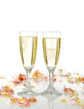 Pair of champagne flutes ready for celebrate. Confetti and white background