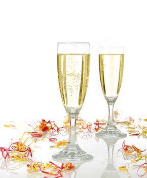 Pair of champagne flutes ready for celebrate. Confetti and white background