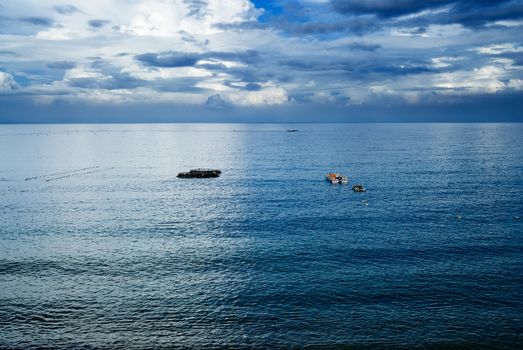 It is beautiful sky and ocean with fishing boats.