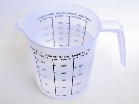 Measuring cup with metric scales for water, sugar and flour