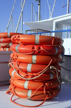 Stacked orange rescue round buoy, sea marine lifesaver