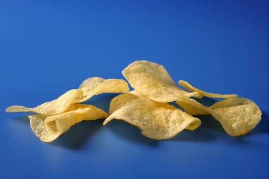 Potato fried chips still over blue background