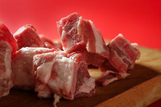 Pig, pork raw meat pieces over red background