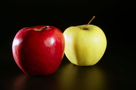 Apple fruit, pair of red and yellow fruits over black background