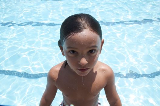 Little boy playing at pool