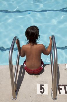 Little boy playing at pool