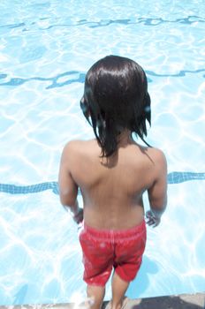 Little boy playing at pool