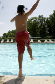 Little boy jumping into pool