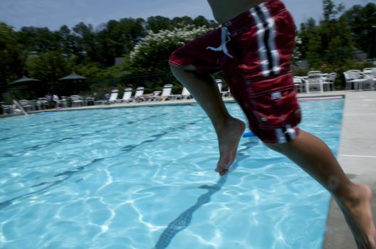 Little boy jumping into pool