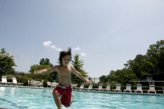Little boy jumping into pool