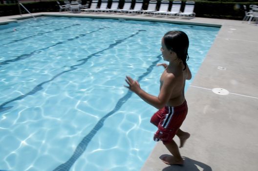Little boy jumping into pool