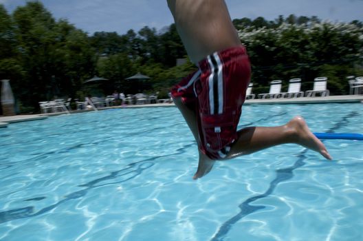 Little boy jumping into pool