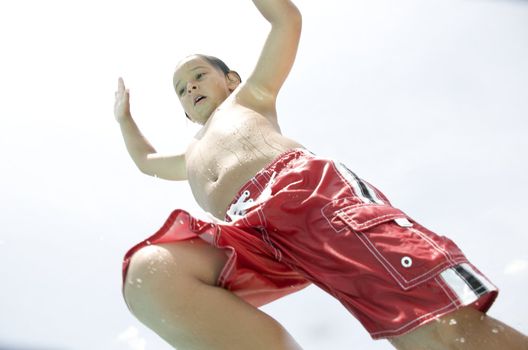 Little boy jumping into pool