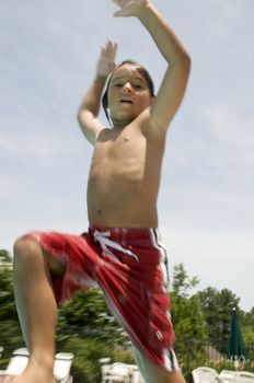 Little boy jumping into pool
