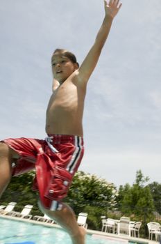 Little boy jumping into pool