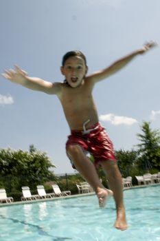 Little boy jumping into pool
