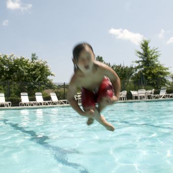 Little boy jumping into pool