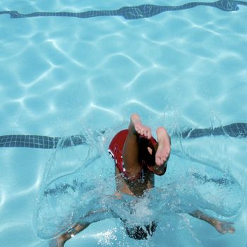 Little boy jumping into pool