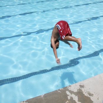 Little boy jumping into pool