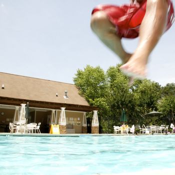 Little boy jumping into pool