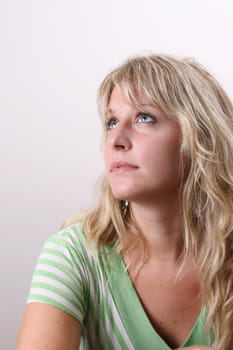 Blond Female model on a white background wearing a green top