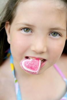 Beautiful teen portrait eating a candy heart in summer