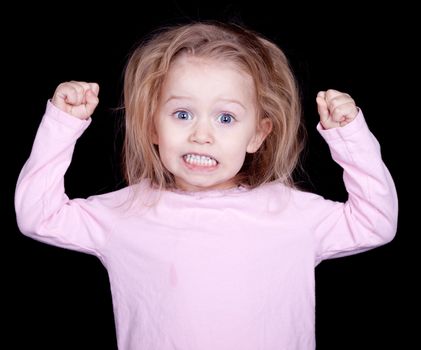 A kid throwing her fists up in anger.  She is acting out and misbehaving.