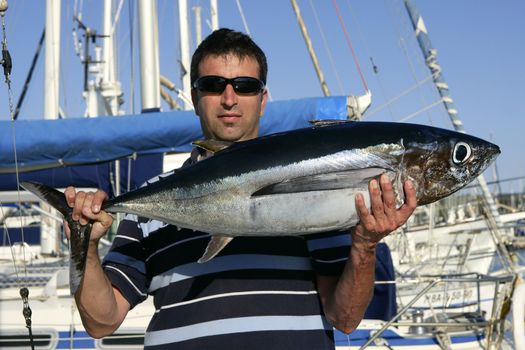 Big game fisherman with saltwater tuna catch in his hands