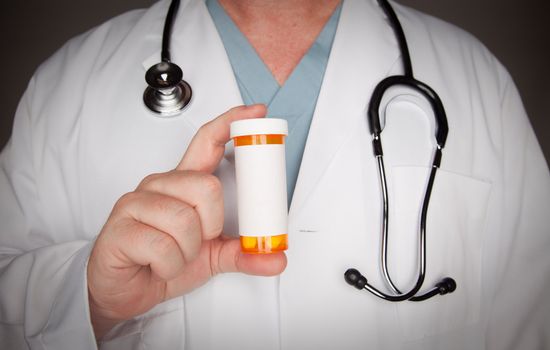 Male Doctor with Stethoscope and Blank Medicine Bottle.