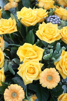 A yellow arrangement with roses and gerberas