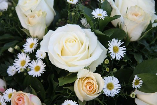 A flower arrangement with soft pink and white roses